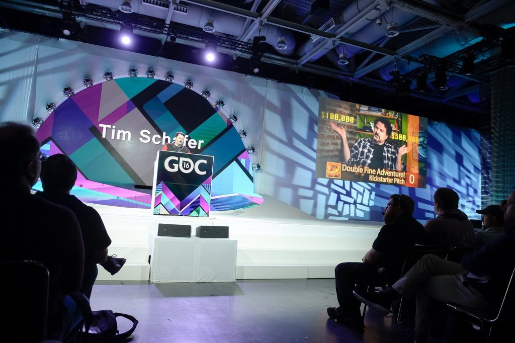 Designer Tim Schafer speaking on stage at the Game Developers Conference 2016